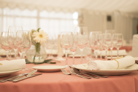 Wedding reception banquet dinner party table place settings set in luxury hotel venue.の写真素材