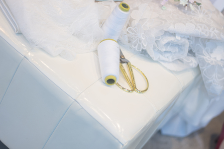 Bridal store hand made dress shop window with scissors, thread and material for sewing.の写真素材