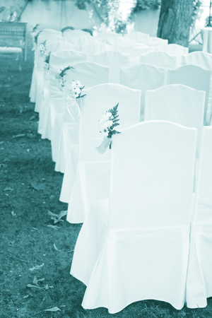 Outdoor summer garden civil wedding seating with flower bouquets decorated for marriage service.の写真素材