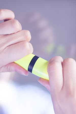 Felt tip permanent highlighter color ink marker pen in hand of young lady.の写真素材