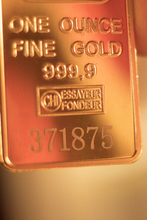 Fine solid gold 999.9 one ounce bullion ingot precious metals bar closeup isolated photo.の写真素材