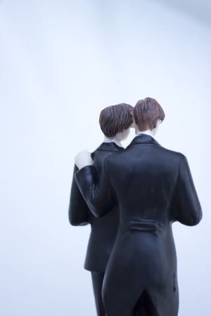 Cake topper gay wedding couple of two male grooms holding romantic marriage embrace of LGBT love.の写真素材