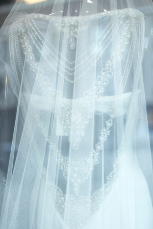 Bridal boutique brides white marriage dress in store window display on retail sale with elegant veil.の写真素材