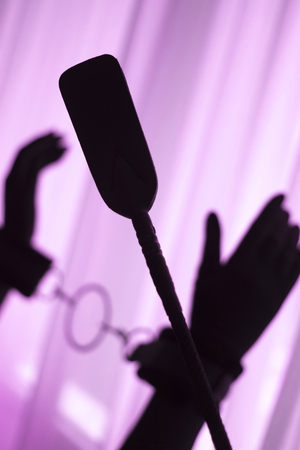 Fetish bondage sadomasochistic gear tied hands woman in artistic silhouette in sexy adult domination game.の写真素材