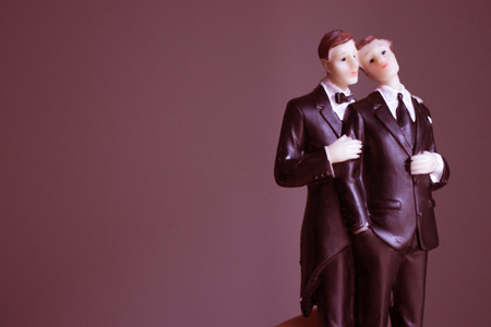 Cake topper gay wedding couple of two male grooms holding romantic marriage embrace of LGBT love.の写真素材
