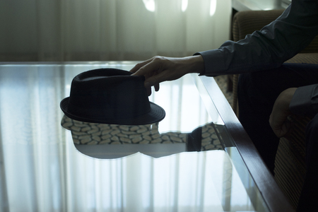 Automatic pistol gun on glass table in bedroom in luxury hotel in silhouette with reflection of window light.の写真素材