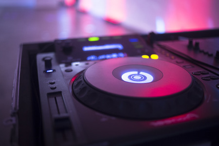 DJ deejay mixing desk equipment in wedding receoption party disco with color discotheque lights.