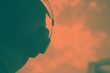 DJ deejay producer wearing closed headphones listening to music in artistic photo.の写真素材