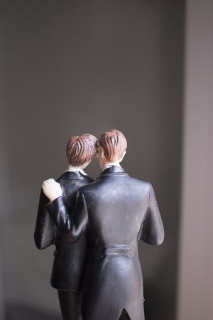 Cake topper gay wedding couple of two male grooms holding romantic marriage embrace of LGBT love.の写真素材