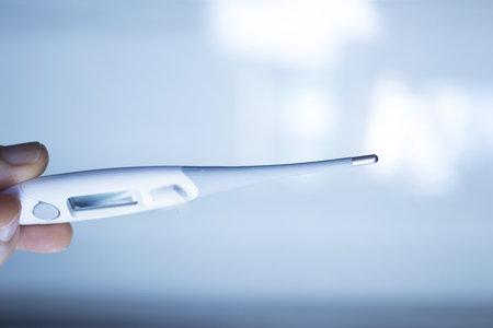 Digital medical thermometer instrument used by doctor or nurse to measure temperature of patientsの写真素材
