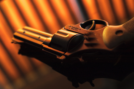 Pistol automatic handgun weapon on table in hotel bedroom in atmospheric dark dramatic photo.
