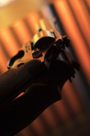 Pistol automatic handgun weapon on table in hotel bedroom in atmospheric dark dramatic photo.の写真素材