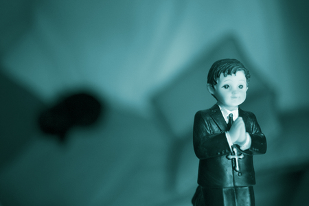 Cake topper Catholic holy communion ceremony religious boy praying to Christian God in church.の写真素材