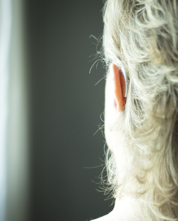 Deaf lady with modern technology digital hearing aid in her ear.の写真素材