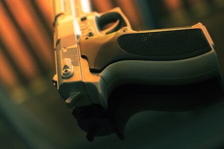 Pistol automatic handgun weapon on table in hotel bedroom in atmospheric dark dramatic photo.