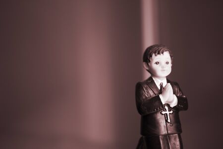 Cake topper Catholic holy communion ceremony religious boy praying to Christian God in church.の写真素材
