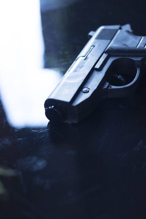 Automatic pistol handgun in artistic light effect moody atmospheric photo creative artistic closeup