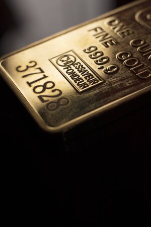 Fine solid gold 999.9 one ounce bullion ingot precious metals bar closeup isolated photo.
