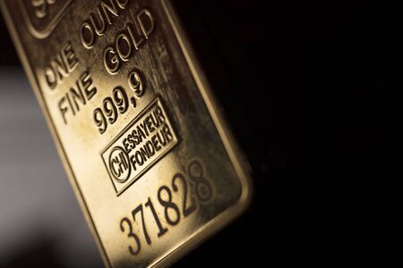Fine solid gold 999.9 one ounce bullion ingot precious metals bar closeup isolated photo.の写真素材