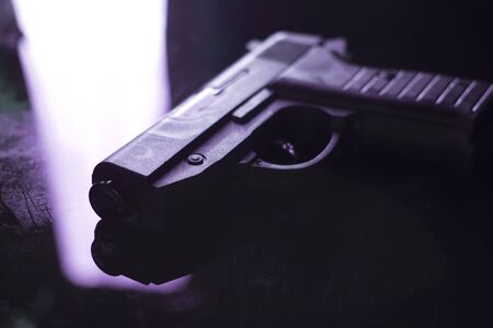 Automatic pistol handgun in artistic light effect moody atmospheric photo creative artistic closeup