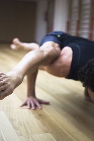 Man yoga teacher practising in gym fitness studio doing advanced asana posture.の写真素材
