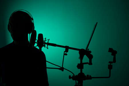 Voiceover artist actor recording voice overs in professional audio studio with large diaphragm...