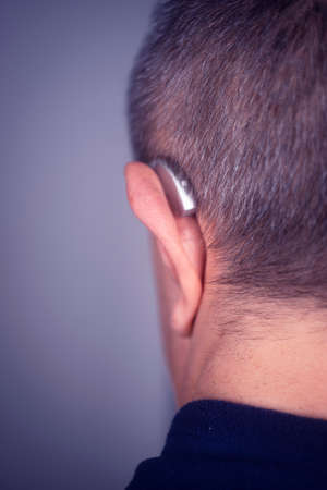 Modern digital hearing aid in ear of middle aged 40s 50s manの写真素材