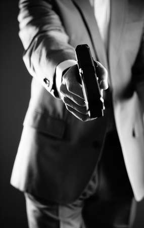 Retro secret agent with pistol revolver gun in hand in vintage crime thriller mockup cover     photo.の写真素材