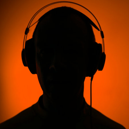 Dj deejay electronic wearing music headphones with coloured lights plain studio background.の写真素材