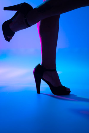 Sexy curvy lady's legs and high heel stiletto shoes in disco dance lights nightclub.の写真素材