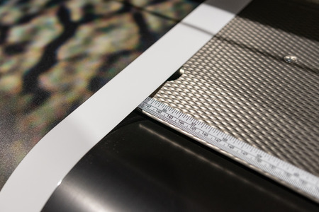 Big professional large scale printer, processing a glossy sheet of paper for color sampling with...