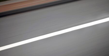Urban highway / road speed backgrounds - panorama of blurred street and kerb, blurred for motion effect.の写真素材