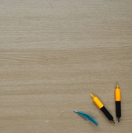Fishing floats and mackeral feather on wooden background - with text space.の写真素材