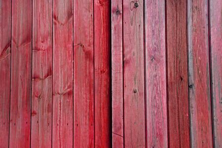 Red and Pink faded wooden doors / planks / panels / vertical slats - Stripes Pattern as a Background Texture.の写真素材