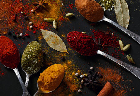 Spices on spoons on a black background shot from aboveの写真素材