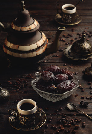 Turkish coffee with dates on a dark wooden table.の写真素材