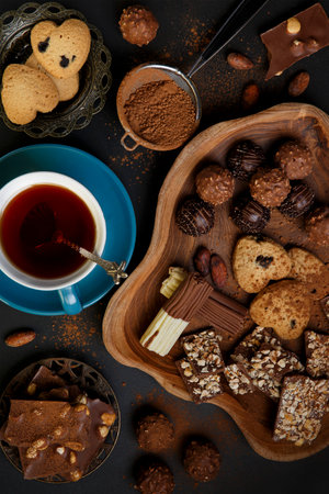 Still life with dark chocolate, sweets and homemade cookies on a black background. Ð¡ulinary backgroundの写真素材