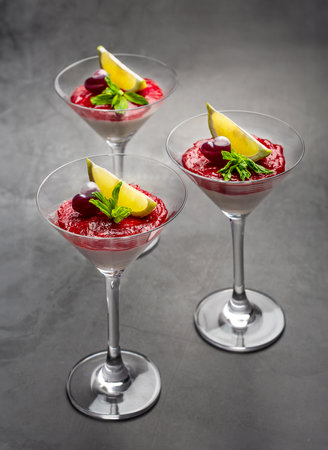 Sweet cherry jam dessert with cream in martini glass on the table, verticalの写真素材