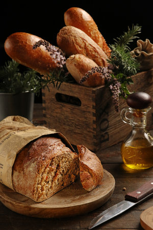 Rustic handmade bread and a jar of olive oil on a wooden tableの写真素材
