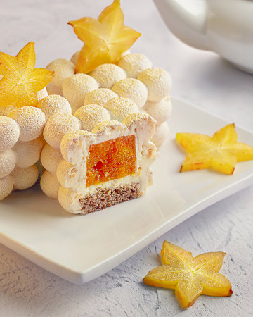 Little mousse cakes covered with white chocolate velvet, decorated of carambolaの写真素材