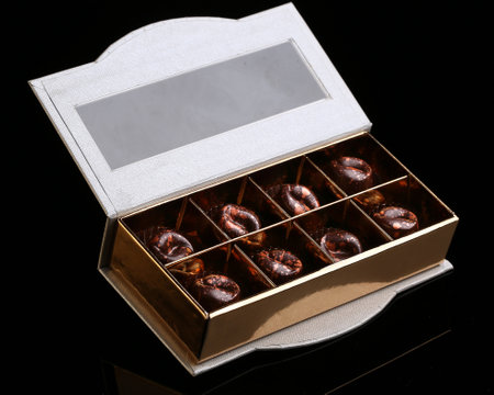 Painted luxury handmade bonbons in a gift box on a black background. Chocolates for Valentine's Day.の写真素材