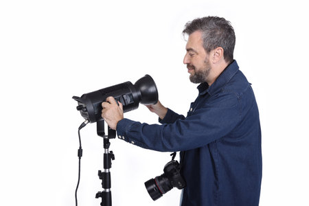 Photographer controlling the light at the studio, close up side view photo. job, profession
