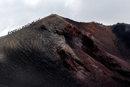 Hikers trekking across the volcanic terrain of Mount Etnaの写真素材