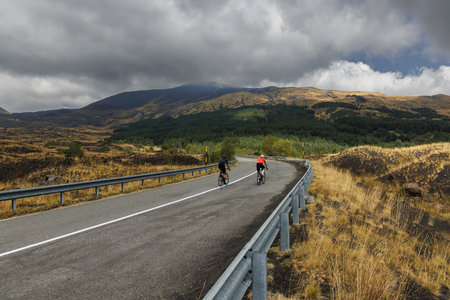 Cyclists on scenic mountain road near Mount Etna, Sicily, Italyの写真素材