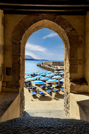 Beach view through ancient stone arch in Cefalu, Sicilyのeditorial素材