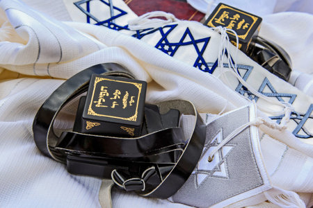 Traditional Jewish prayer items including tefillin and tallit arranged on a table. Concept of...