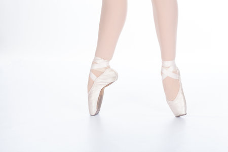 En Pointe CORRECT mid stride Close up of young female ballet dancer showing various classic ballet feet positions in pink satin ribbon lacings and silk pointe shoes broken inの写真素材
