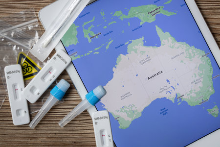 Covid home testing kits laying on a table next to a map of Australiaの写真素材
