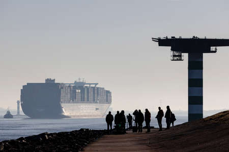 Rotterdam, Netherlands - 2-27-2022: A group of shipspotters photographing ships entering the port of...