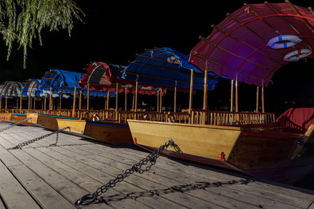 The historic pletna rowing boats of Bled docked on the quay at nightの写真素材
